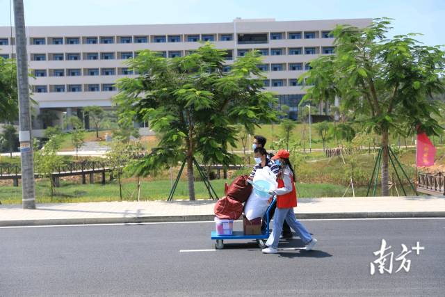 广东工业大学揭阳校区迎新，志愿者帮助新生搬运行李。